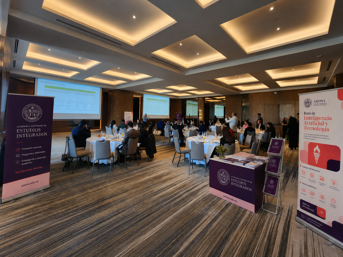 Sala de evento ASEINA con banners de rutas formativas